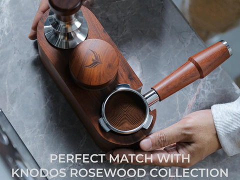 KNODOS 54mm espresso distribution tool in rosewood with stainless steel components on a wooden stand