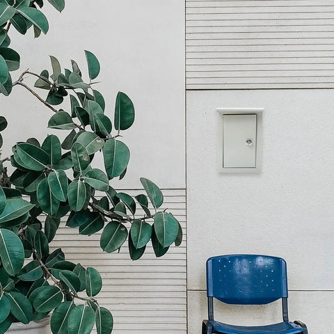 Outdoor Weatherproof Metal Junction Box Electrical Distribution Enclosure 160x300x200mm wall-mounted near a plant and chair