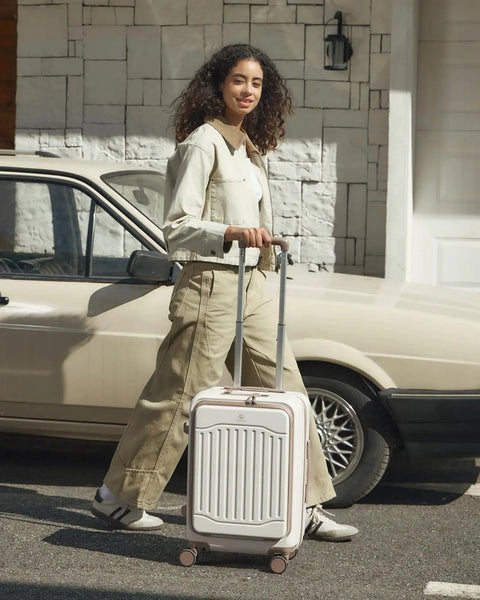 Woman with Expandable 22x14x9 Carry On Luggage With USB Charging Port Front Pocket And TSA Lock PC Hardside Spinner Wheels