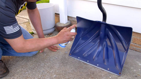 Person applying 16 TDL Advanced Dry Lube With Teflon The Do It All Go To For Everyday Household Lubrication on blue shovel blade.