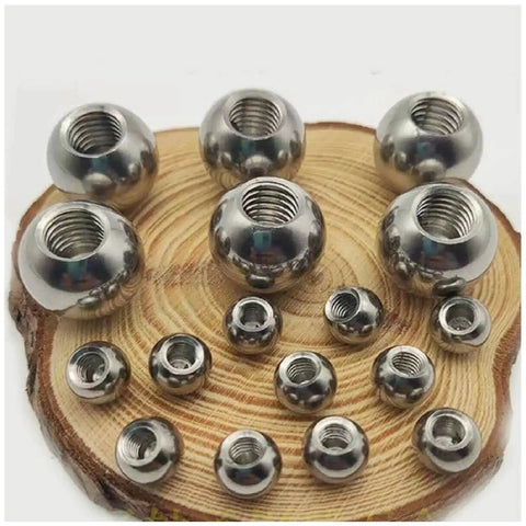 Assorted stainless steel threaded balls with M8 threads, half-holes, sizes 15-60mm on wooden surface for DIY projects.