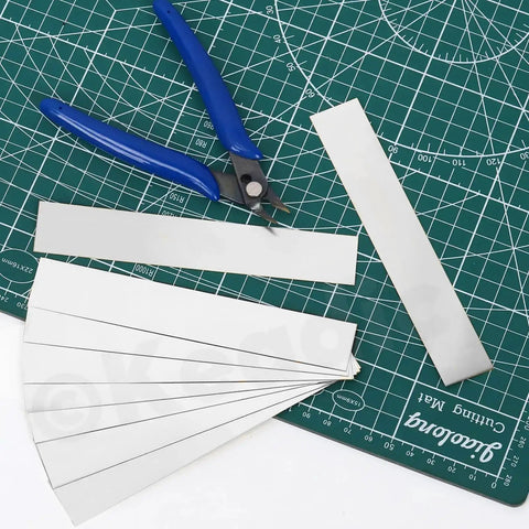 10 Piece Stainless Steel Shim Stock Set With 1 Inch Width And 6 Inch Length, 0.01 Inch Thick, displayed on mat with cutter