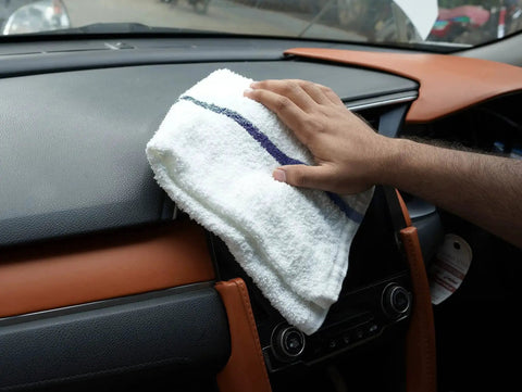 Value Pack Of 36 Absorbent 16x19 Inch Terry Cloth Cleaning Rags For Home And Business being used to clean a car dashboard