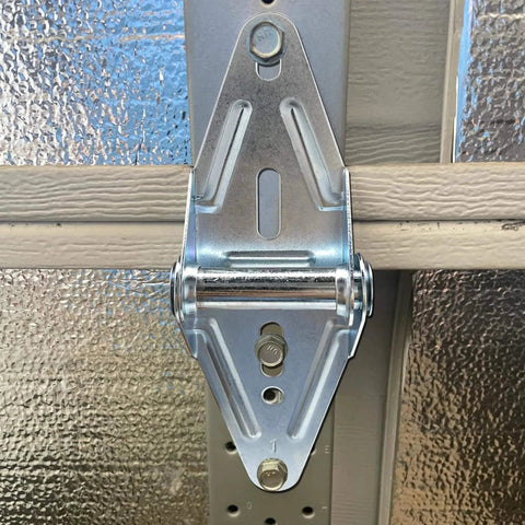 Two Eighteen Gauge Narrow Body Garage Door Hinges In Cold Rolled Steel With Galvanized Finish Replacement Hardware Installed on Door