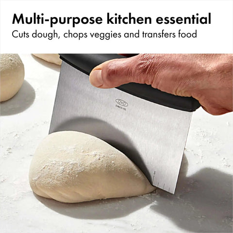 Stainless Steel All Purpose Scraper and Dough Cutter for Pizza Bread and Cookie Dough in use on dough, ergonomic handle visible.