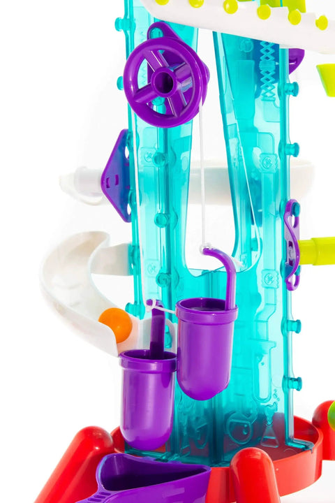 Close-up of Thames and Kosmos Gumball Machine Maker toy with turquoise translucent frame and purple wheel and cups.