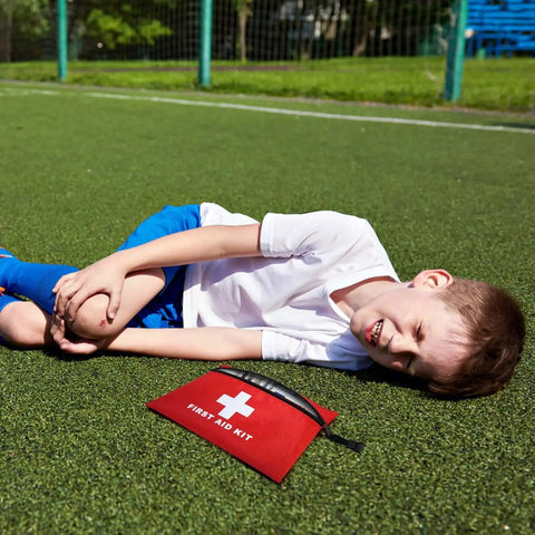 Portable Empty First Aid Kit Pouch with Zippered Opening for Emergency Use shown on grass with injured child nearby