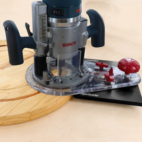 Edge And Mortise Router Guide For Straight And Curved Edges Universal Fit For Plunge And Fixed Base Routers Built In Mortise Guide All In One Large Surface For Radial Cuts Includes Two Non Marring Mortising Pins And Bonus Offset Base attached to a power router on a wooden board.
