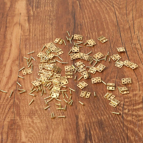 Gold Copper Mini Hinges For Crafts Pack Of 500 With Matching Screws scattered on wood surface.