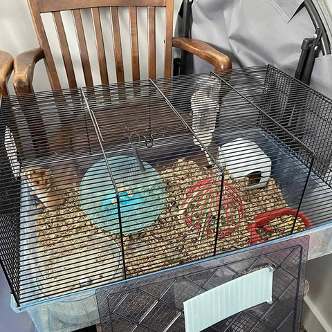 10 Pack Metal Spring Latch Hooks For Pet Cage Doors And Small Animals installed on a pet cage with bedding and accessories.