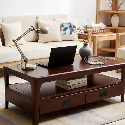 Modern living room with wooden coffee table, laptop, and decorative items; sofa and shelf in background.