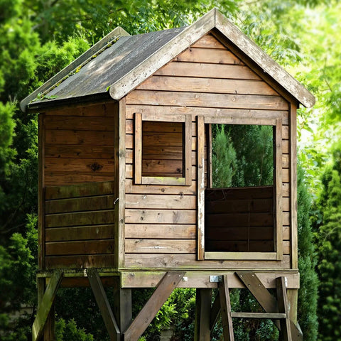 Wooden playhouse on stilts in a garden setting, showcasing timber construction, compatible with Heavy Duty Wood Structural Screws 14 X 8 50 Pack With Hex Head Lag Screws, Rust Resistant Timber Screws Built Tough For Timber Log And Landscaping Projects, ACQ Treated Lumber Compatible, Green Coated Outdoor Fasteners. Suitable for kids.