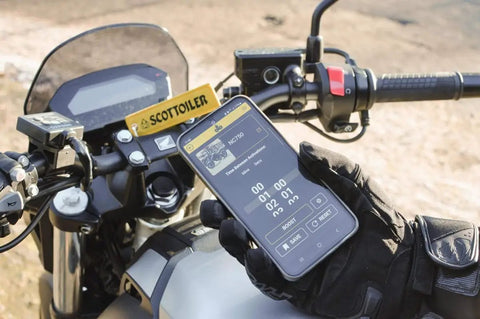 Motorcyclist using app for Micro XSystem 3.0 Bluetooth Automatic Motorcycle Chain Lubrication on dashboard