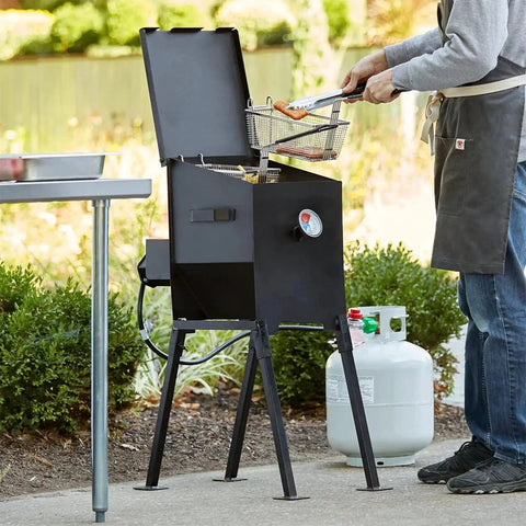 Person using a turkey fryer powered by High Pressure 10 PSI Propane Regulator Hose Assembly With 48 Inch Hose And Flow Regulating Brass Valve