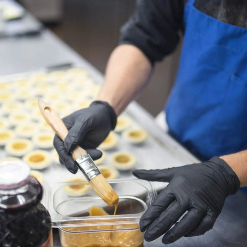 Chef wearing Black Nitrile Disposable Gloves 3 Mil Powder Free Food Safe X Large Box Of 100 while glazing food