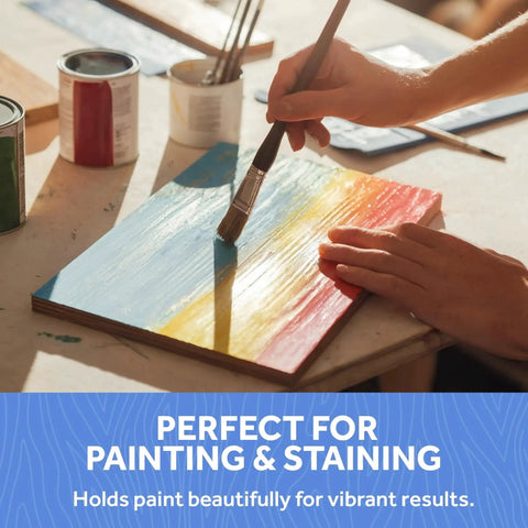 Person painting a Custom Cut Baltic Birch Plywood sheet with blue, yellow, and red stripes for crafting projects.