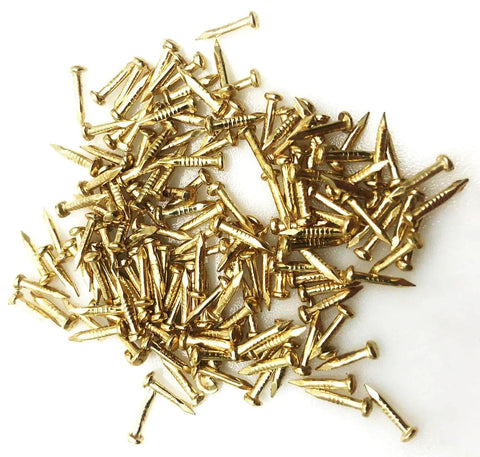 Close-up of gold tone nails from 50Pcs Mini Brass Hinges Set With Mounting Nails, 180 Degree Rotation, for jewelry boxes and mini furniture.