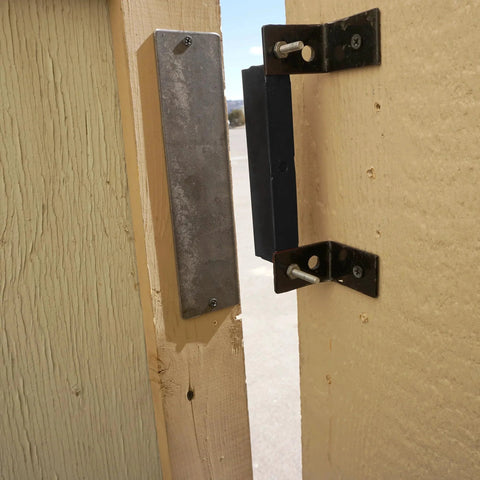AM3 RM100C Magnet Catch Industrial Type with mounting holes installed on wooden enclosure, powder coated black finish, 100 lb capacity