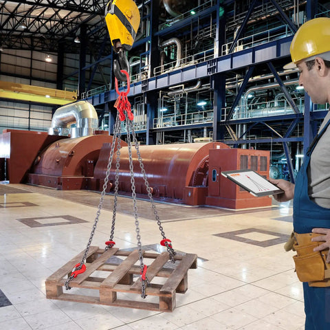 Front view of a 4-leg 5/16 in x 5 ft chain sling with red hooks lifting a wooden pallet in an industrial plant