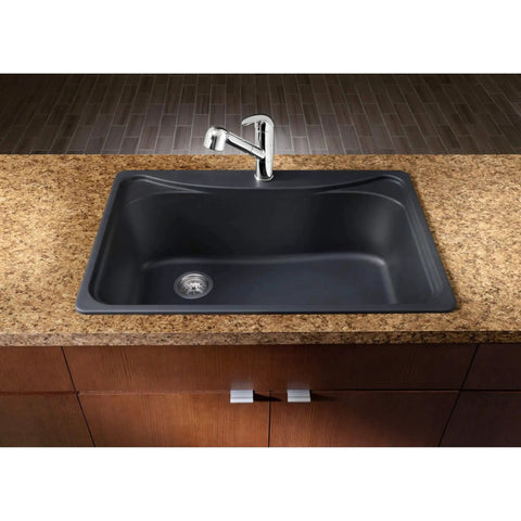 Top view of a black kitchen sink with chrome faucet installed in a brown granite countertop, surrounded by wooden cabinets