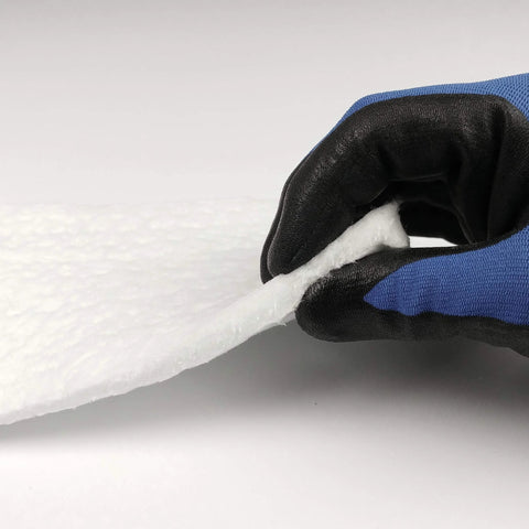Ceramic fiber insulation blanket, 1/4 in thick, 16 x 240 in, white sheet, held by blue glove