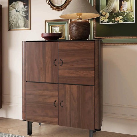 Wooden cabinet with four doors featuring metal handles, decorated with a lamp and artwork in a classic living room setting.