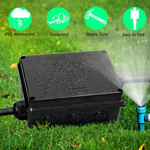 Outdoor IP65 Waterproof Electrical Junction Box in Tough ABS Plastic on grass with water spray, showcasing weatherproof feature