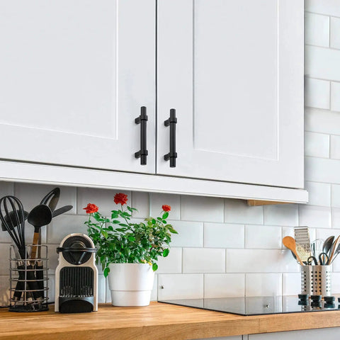 Matte Black 25 Pack Cabinet Handles 3 Inch Hole Centers installed on white kitchen cabinet doors, showcasing modern design.