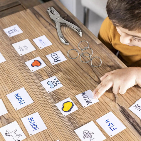 Kid using Super Handy Single Hole Punch For Crafts And Scrapbooks, Quarter Inch Hole, Punches Up To 8 Sheets, Includes 10 Binder Rings, Silver.