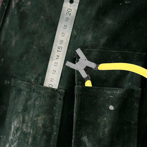 Handheld Single Hole Punch Plier For Paper And Tags with 2mm Metal Punch, stored in pocket next to ruler for size reference.