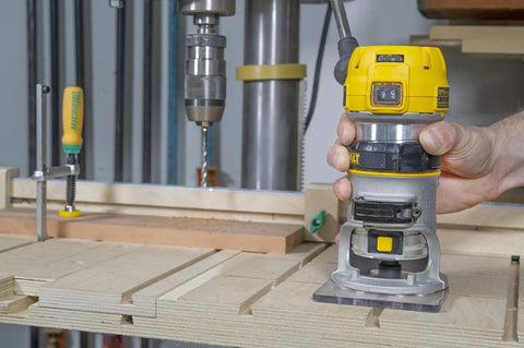 Woodworking bench with a handheld router and Matchfit Dovetail Clamps Four Pack Exclusive Bundle with Dovetail Router Bit in use