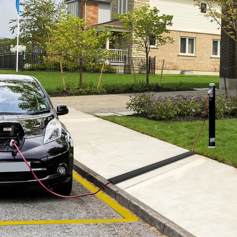 Heavy Duty PVC Floor Cord Cover For Wires And Cables black ramp in use over sidewalk, preventing trip hazards, for home or office safety.