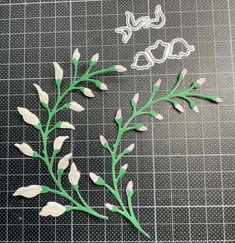 3 Piece Flower Leaf Branches Metal Die Cuts Set For DIY Embossing And Card Making with floral leaves frame stencils on a grid mat.