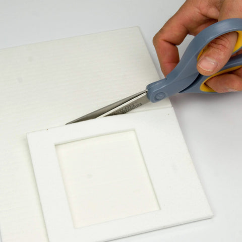 Lynn Manufacturing high-temp gasket paper being cut with blue Westcott scissors; 1/8 in, 15x24 in