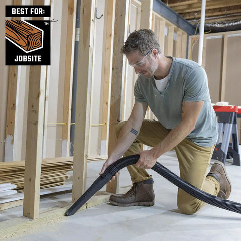 Man using Heavy Duty Wet Dry Vac Pro Attachment Kit For Two And A Half Inch Hoses With Seven Foot Dual Flex Hose Industrial Grade Shop Vacuum Accessories For Big Cleanups And Tough Projects in a workshop.
