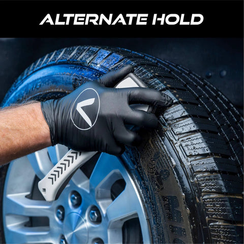 Person using Ergonomic Tire And Wheel Cleaning Brush For Cars, 10.3 Inch Long With Short Stiff Bristles on a car tire for detailing.