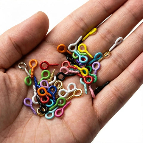 Hand holding 600 piece mixed color mini screw eye pins for jewelry making and DIY crafts, tiny eye hook pins with threads, no gold or silver.