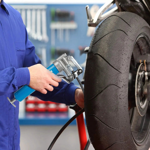 Person using Mini Grease Gun Kit 3000 PSI With Double 3oz Cartridges And 12 Inch Flex Hose Pro Grade Reinforced Coupler on tire