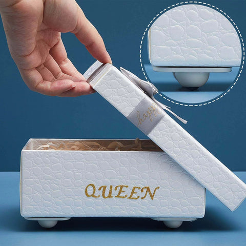 White box with lid reading 'QUEEN' and embossed texture, hand lifting lid to reveal interior, designed with decorative purposes.