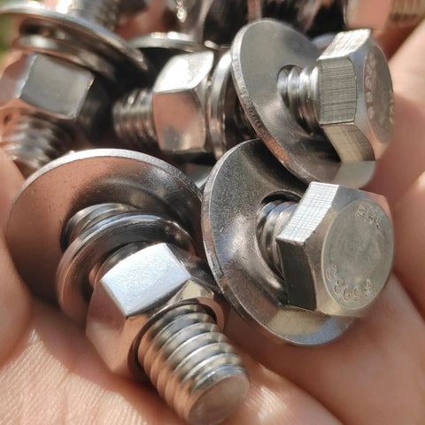 Close-up of 8 Sets 3/8-16 X 1-1/4 Stainless Steel Hex Head Screws Kit With Nuts Flat And Lock Washers in hand