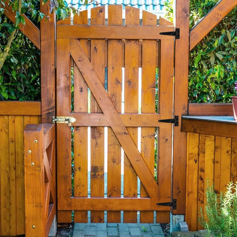 Wooden gate with 14 Pack 4 Inch T Hinge Heavy Duty Shed Door Hinges Gate Strap Black Tee Hinge For Wooden Fences installed on the side.