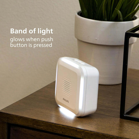 Wireless Security Doorbell Kit With Realistic Decoy Cam And Motion Activated Light, white unit on brown table.