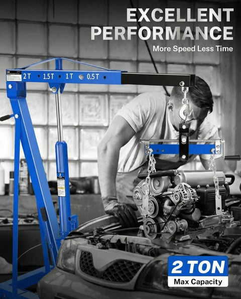 Blue 2-ton hydraulic engine hoist crane with folding boom and 6 locking wheels lifting a car engine in a garage