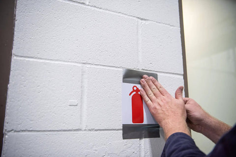 Person applying Multi-Use Silver Duct Tape 1.88 in x 60 yd x 7 mil, Contractor Grade for temporary repair on wall