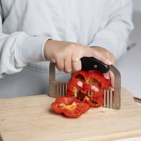 Person using Crinkle Cutter For Veggies And Fruits, Wavy Slicer For Waffle Fries, Chips, Pickles, And More, Durable Stainless Steel Kitchen Gadget By Fox Run on red pepper