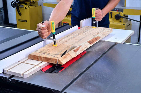 Matchfit Dovetail Clamps DVC 538K2 With X Pad Set securing a wooden board on a table saw using 1/2-inch 14-degree dovetail grooves.