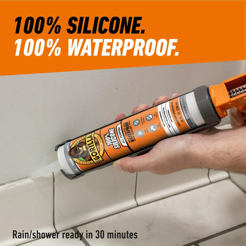 Gorilla 100% silicone sealant cartridge, 10 oz, clear, being applied with caulk gun along tile edge