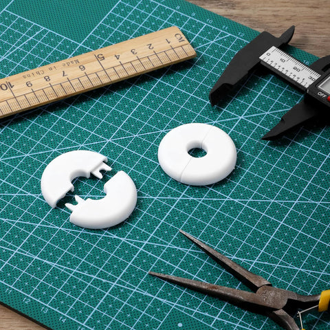 White plastic wall cable grommets, 4-pack, donut-shaped hole covers for wire routing.