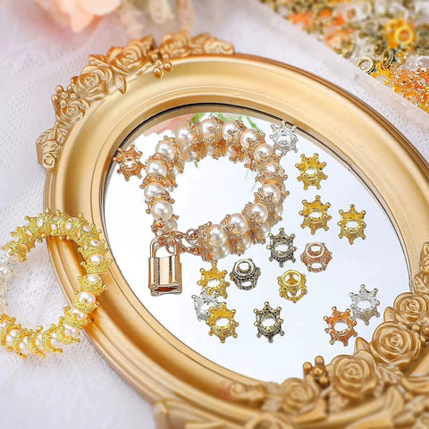 200 Piece Mini Crown Charms For Jewelry Making Colorful Gold And Silver Mixed Metals displayed on decorative frame mirror