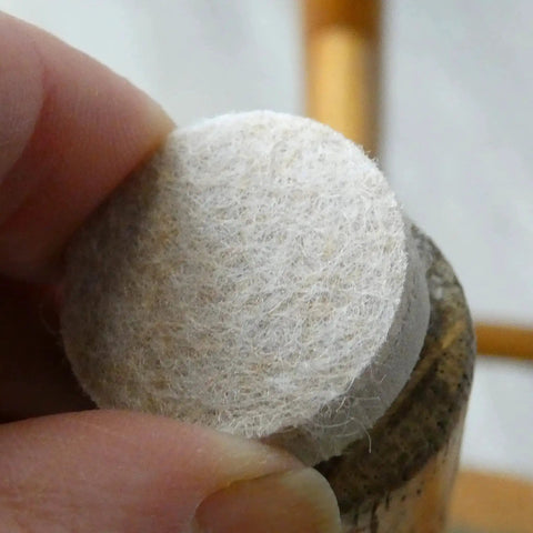Applying a 1 Inch Round Self Adhesive Felt Furniture Slider for Hard Floors Leveling Pads to a chair leg to stop scratches